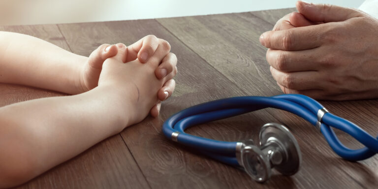 The hands of the child and the doctor close-up, the reception at the doctor. The concept of medicine, a doctor’s appointment, health care. Copy space.